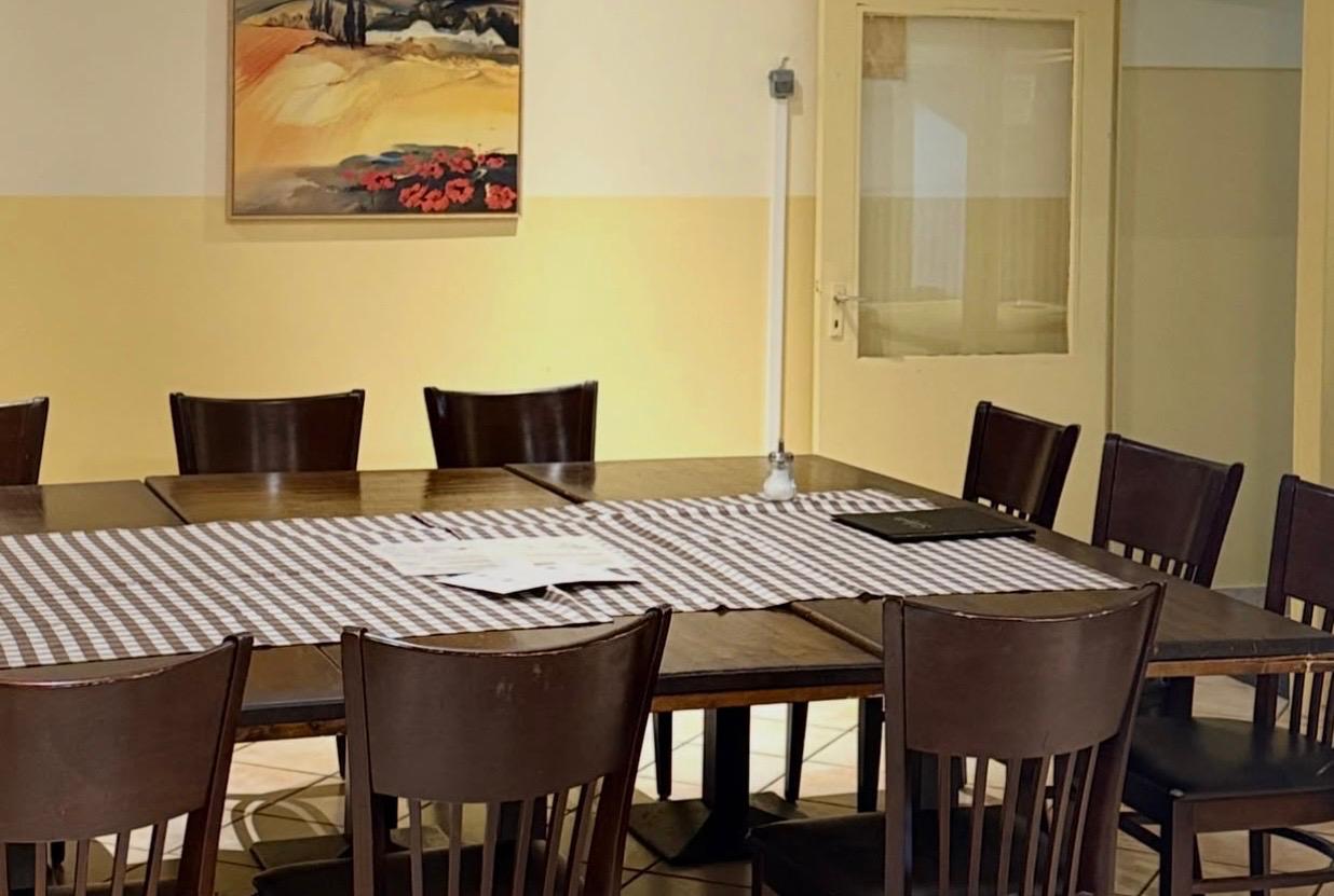 Sitzbereich an der Kegelbahn mit langer Tafel und karierter Tischdecke